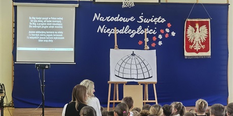 Powiększ grafikę: Uczniowie i nauczyciele zebrani w sali gimnastycznej podczas apelu..