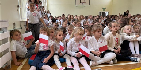 Powiększ grafikę: Uczniowie i nauczyciele zebrani w sali gimnastycznej podczas apelu..