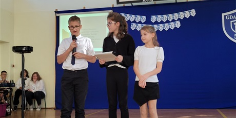 Powiększ grafikę: Uczniowie w sali gimnastycznej  podczas apelu przedstawiają program artystyczny.