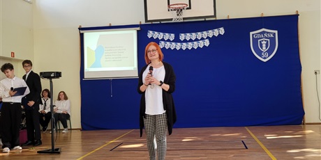 Powiększ grafikę: Pani wicedyrektor przemawia na apelu  w sali gimnastycznej.