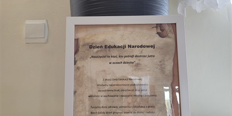 Powiększ grafikę: Ramka z życzeniami z okazji Dnia Edukacji i róża na stoliku.