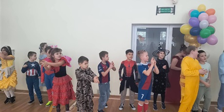 Powiększ grafikę: Uczniowie w przebraniach karnawałowych i nauczyciele podczas balu w sali gimnastycznej.