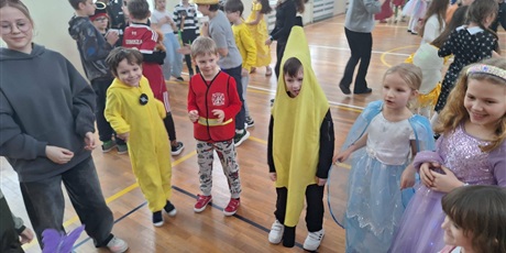 Powiększ grafikę: Uczniowie w przebraniach karnawałowych i nauczyciele podczas balu w sali gimnastycznej.