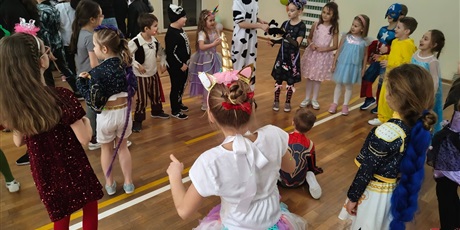 Powiększ grafikę: Uczniowie w przebraniach karnawałowych i nauczyciele podczas balu w sali gimnastycznej.