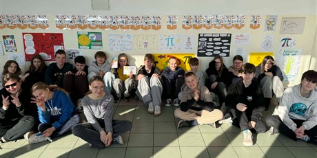 Powiększ grafikę: Zbiorowe zdjęcie uczniów  przy plakatach informujących o Dniu matematyki i liczby pi na korytarzu szkolnym.