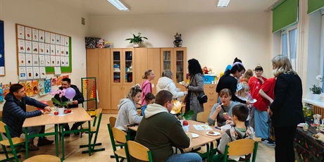 Powiększ grafikę: Dzieci i rodzice w kawiarence w sali lekcyjnej.