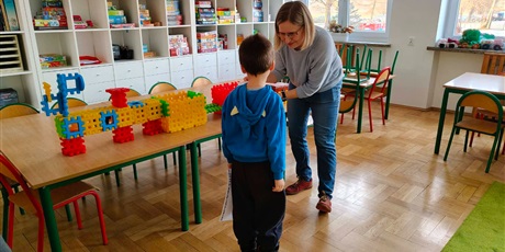Powiększ grafikę: Uczeń i nauczycielka podczas wykonywania zadania z klockami w świetlicy szkolnej.