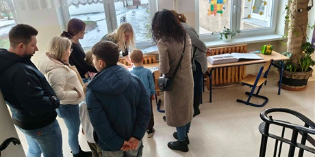 Powiększ grafikę: Nauczyciel, rodzice i dzieci podczas powitania na Dniu Otwartym.