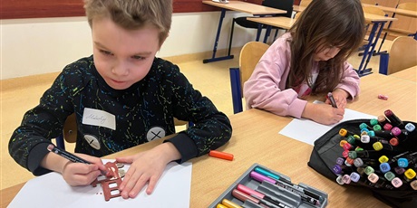 Powiększ grafikę: Uczniowie podczas wykonywania zadania plastycznego w sali lekcyjnej.