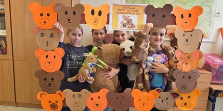 Powiększ grafikę: Zbiorowe zdjęcie uczniów z pluszowymi maskotkami w sali lekcyjnej.