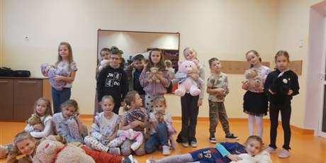 Powiększ grafikę: Zbiorowe zdjęcie uczniów z pluszowymi maskotkami w sali lekcyjnej.