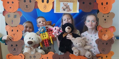 Powiększ grafikę: Zbiorowe zdjęcie uczniów z pluszowymi maskotkami w sali lekcyjnej.