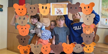Powiększ grafikę: Zbiorowe zdjęcie uczniów z pluszowymi maskotkami w sali lekcyjnej.