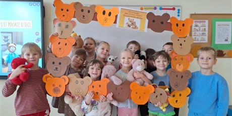 Powiększ grafikę: Zbiorowe zdjęcie uczniów z pluszowymi maskotkami w sali lekcyjnej.