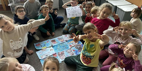 Powiększ grafikę: Uczniowie prezentują wykonane prace plastyczne o misiach.