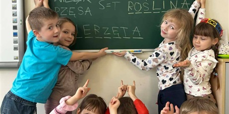 Powiększ grafikę: Uczniowie rozwiązują rebusy i zagadki na tablicy w sali lekcyjnej.