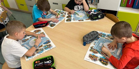 Powiększ grafikę: Uczniowie rozwiązują rebusy i zagadki  w sali lekcyjnej.