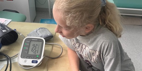 Powiększ grafikę: Uczennica odczytuje zapis na ciśnieniomierzu.