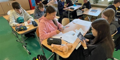 Powiększ grafikę: Uczniowie w sali lekcyjnej przygotowują plakaty.