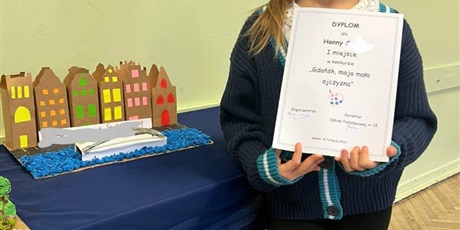 Powiększ grafikę: Uczennica prezentująca swój dyplom zdobyty w  Konkursie.