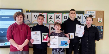 Powiększ grafikę: Nauczyciele oraz uczniowie z nagrodami i dyplomami za konkurs w sali lekcyjnej.