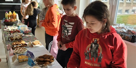 Powiększ grafikę: Uczniowie podczas kiermaszu żywności na korytarzu szkolnym.
