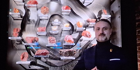 Powiększ grafikę: Mężczyzna prezentuje bursztyny przy plakacie