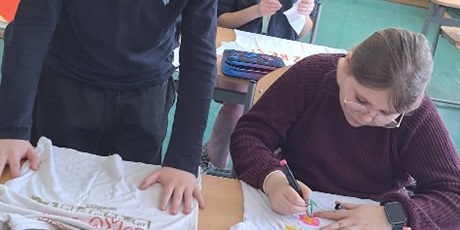 Powiększ grafikę: Uczniowie wykonują koszulki z zapisanymi trudnymi słowami .