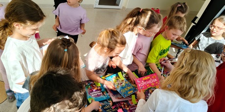 Powiększ grafikę: Uczniowie oglądają książki na kiermaszu na korytarzu szkolnym.