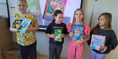 Powiększ grafikę: Uczniowie prezentują książki w sali lekcyjnej.