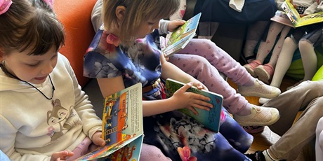 Powiększ grafikę: Uczniowie czytają książki w bibliotece.