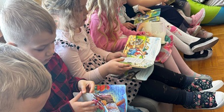 Powiększ grafikę: Uczniowie czytają książki w bibliotece.