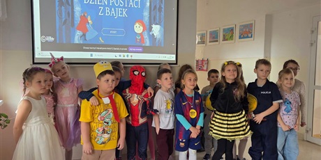 Powiększ grafikę: Zbiorowe zdjęcie uczniów przebranych  za postacie z bajek na korytarzu szkolnym.