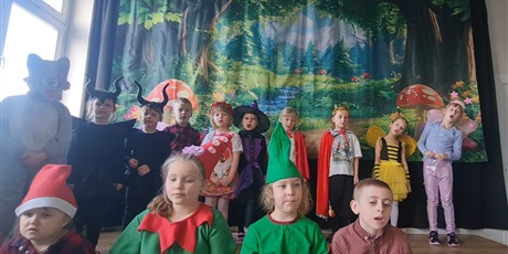 Powiększ grafikę: Uczniowie w przebraniach podczas występu na scenie.