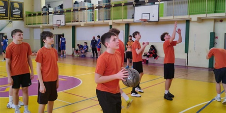 Powiększ grafikę: Uczniowie podczas rozgrzewki z piłkami w sali gimnastycznej.