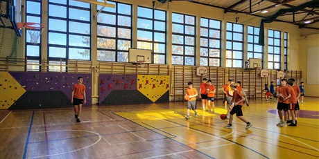 Powiększ grafikę: Uczniowie podczas rozgrzewki z piłkami w sali gimnastycznej.