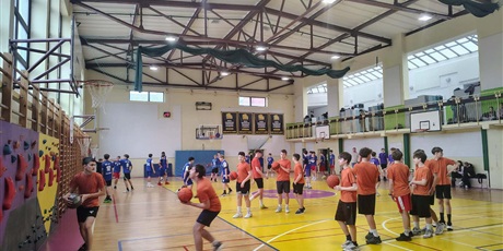 Powiększ grafikę: Uczniowie podczas rozgrzewki z piłkami w sali gimnastycznej.