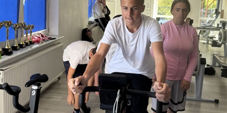 Powiększ grafikę: Uczeń na rowerze stacjonarnym podczas zawodów.