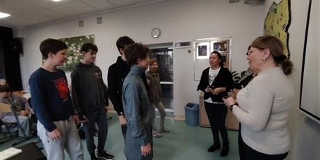 Powiększ grafikę: Uczniowie odbierają nagrodę od przedstawicielek Rady Dzielnicy i pani dyrektor  w sali lekcyjnej.