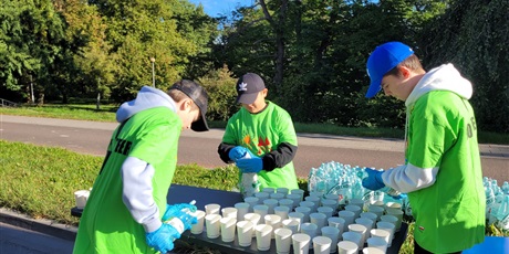 Powiększ grafikę: Uczniowie podczas przygotowania napoi dla uczestników półmaratonu.