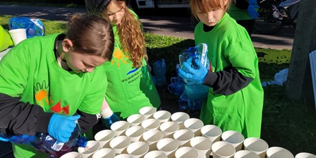 Powiększ grafikę: Uczniowie podczas przygotowania napoi dla uczestników półmaratonu.