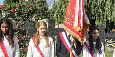Powiększ grafikę: Uczniowie ze sztandarem szkoły podczas uroczystości patriotycznej