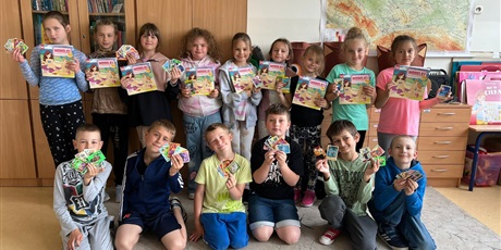 Powiększ grafikę: Zbiorowe zdjęcie uczniów z prezentami w sali lekcyjnej