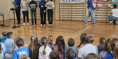 Powiększ grafikę: Uczennice demonstrują wykonane prace podczas apelu w sali gimnastycznej.