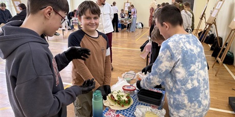 Powiększ grafikę: Uczniowie przygotowują zdrowe przekąski w sali gimnastycznej.