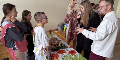 Powiększ grafikę: Uczniowie przygotowują zdrowe przekąski w sali gimnastycznej. Jury ocenia przekąski.