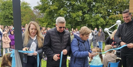 Powiększ grafikę: Goście i pani dyrektor przecinają wstęgę - otwierają Klasę pod Chmurką.