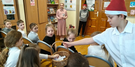 Powiększ grafikę: Uczniowie podczas pasowania na czytelnika w bibliotece.