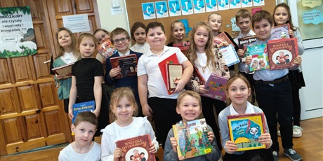 Powiększ grafikę: Uczniowie i nauczyciele  podczas pasowania na  czytelnika w bibliotece.