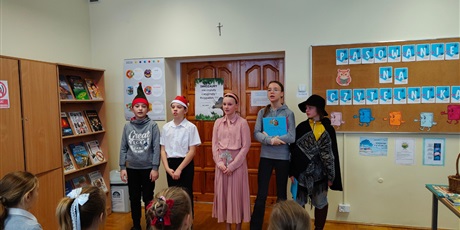 Powiększ grafikę: Uczniowie biorący udział w przedstawieniu podczas pasowania na czytelnika w bibliotece.